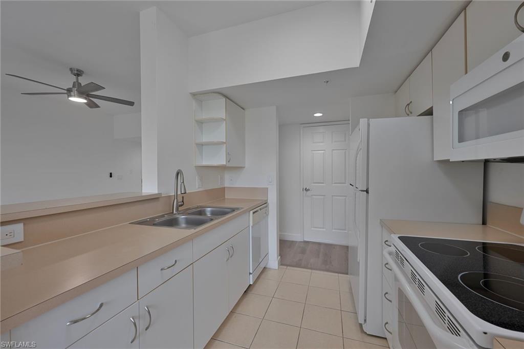 1885 Florida Club Drive, Unit 8305 Naples, FL 34112 - Photo 6 of 22 Kitchen with white cabinets, white appliances, light countertops, open shelves, and recessed lighting