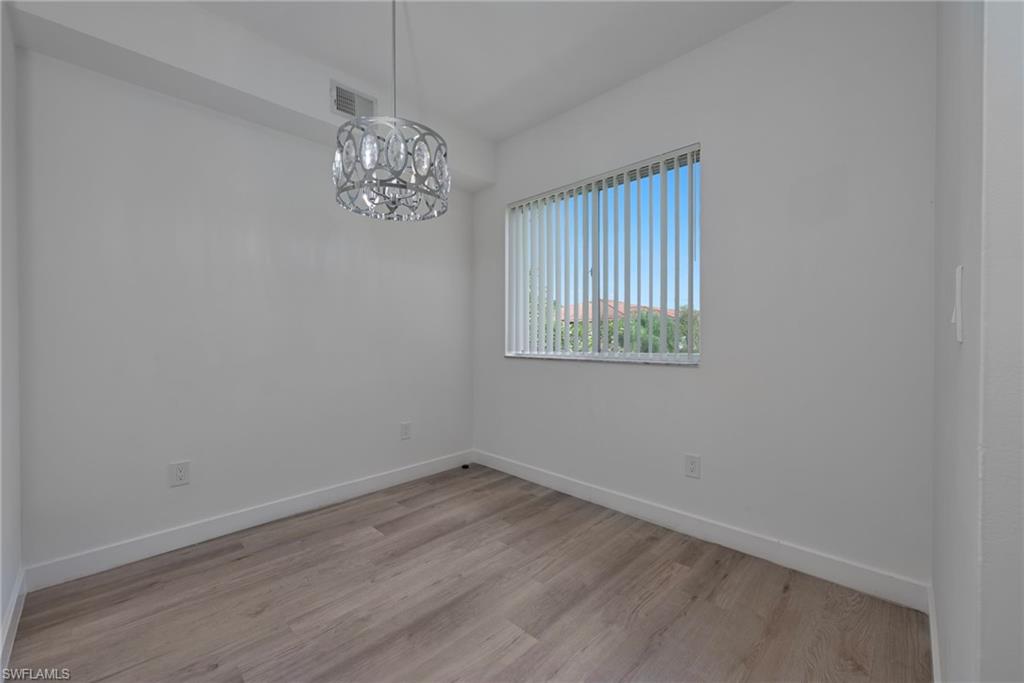 1885 Florida Club Drive, Unit 8305 Naples, FL 34112 - Photo 8 of 22 Unfurnished dining room featuring light wood-style flooring and a chandelier