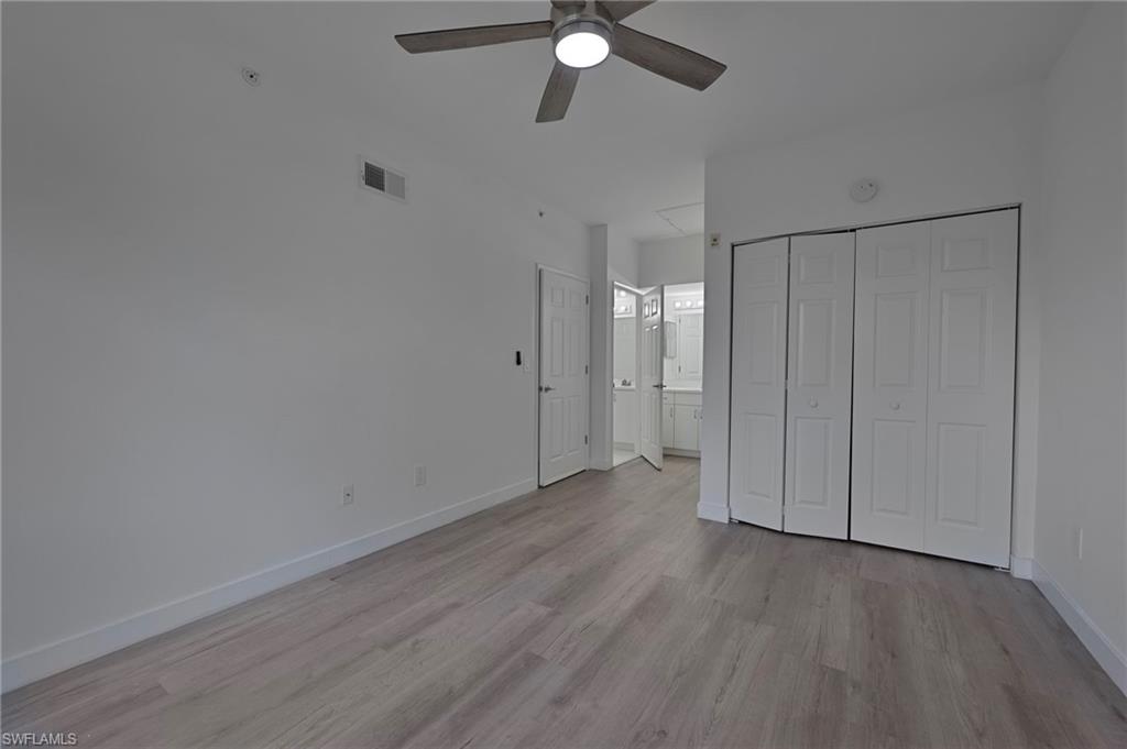1885 Florida Club Drive, Unit 8305 Naples, FL 34112 - Photo 10 of 22 Bedroom with a closet, ensuite bathroom, light wood-style floors, and ceiling fan