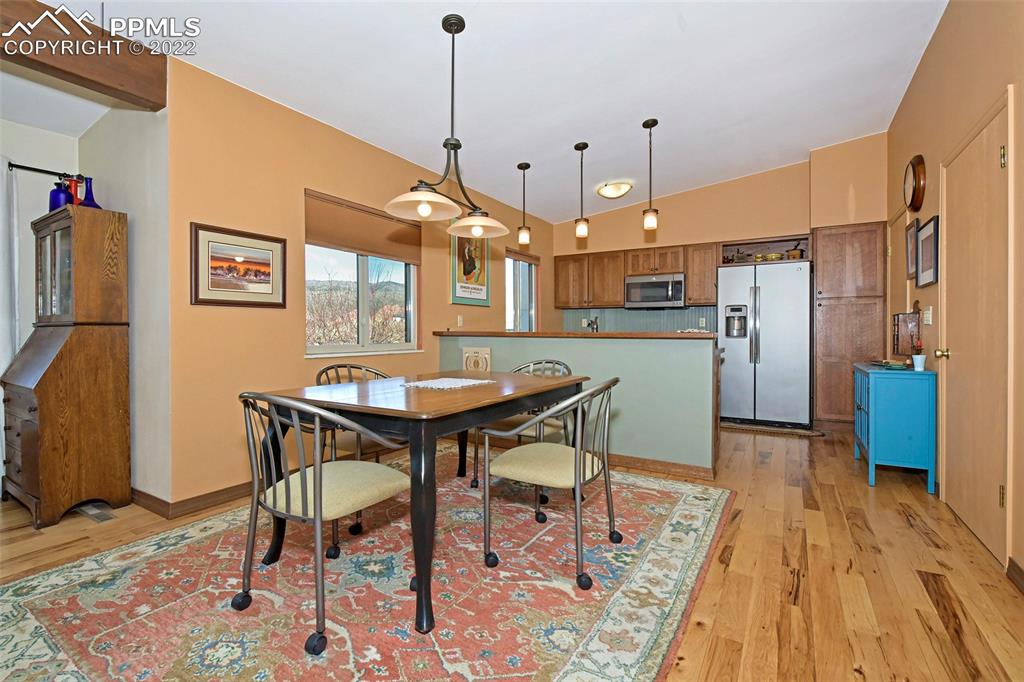 1142 Fontmore Road, Unit C Colorado Springs, CO 80904 - Photo 12 of 33 a kitchen with stainless steel appliances a dining table chairs refrigerator and sink