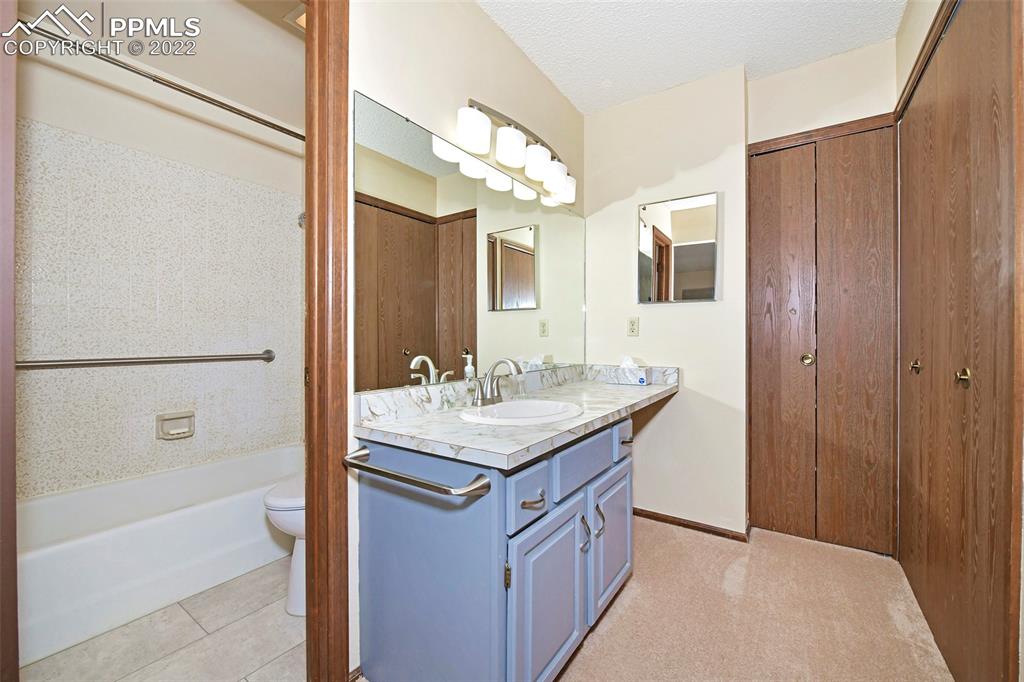 1142 Fontmore Road, Unit C Colorado Springs, CO 80904 - Photo 18 of 33 a bathroom with a granite countertop sink a mirror and a bathtub