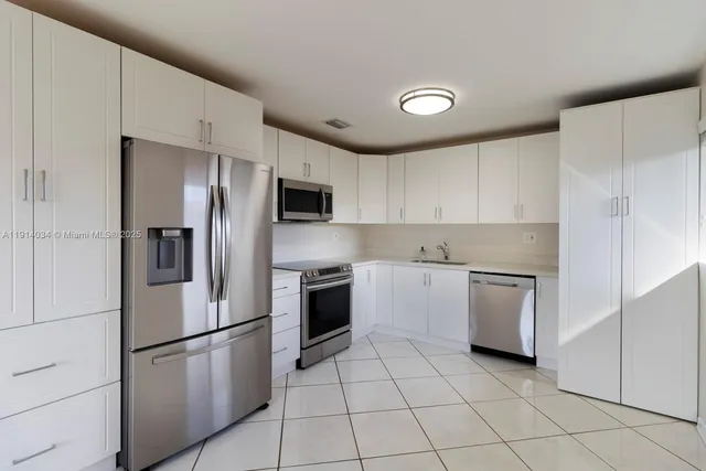 a kitchen with stainless steel appliances granite countertop a refrigerator sink and stove