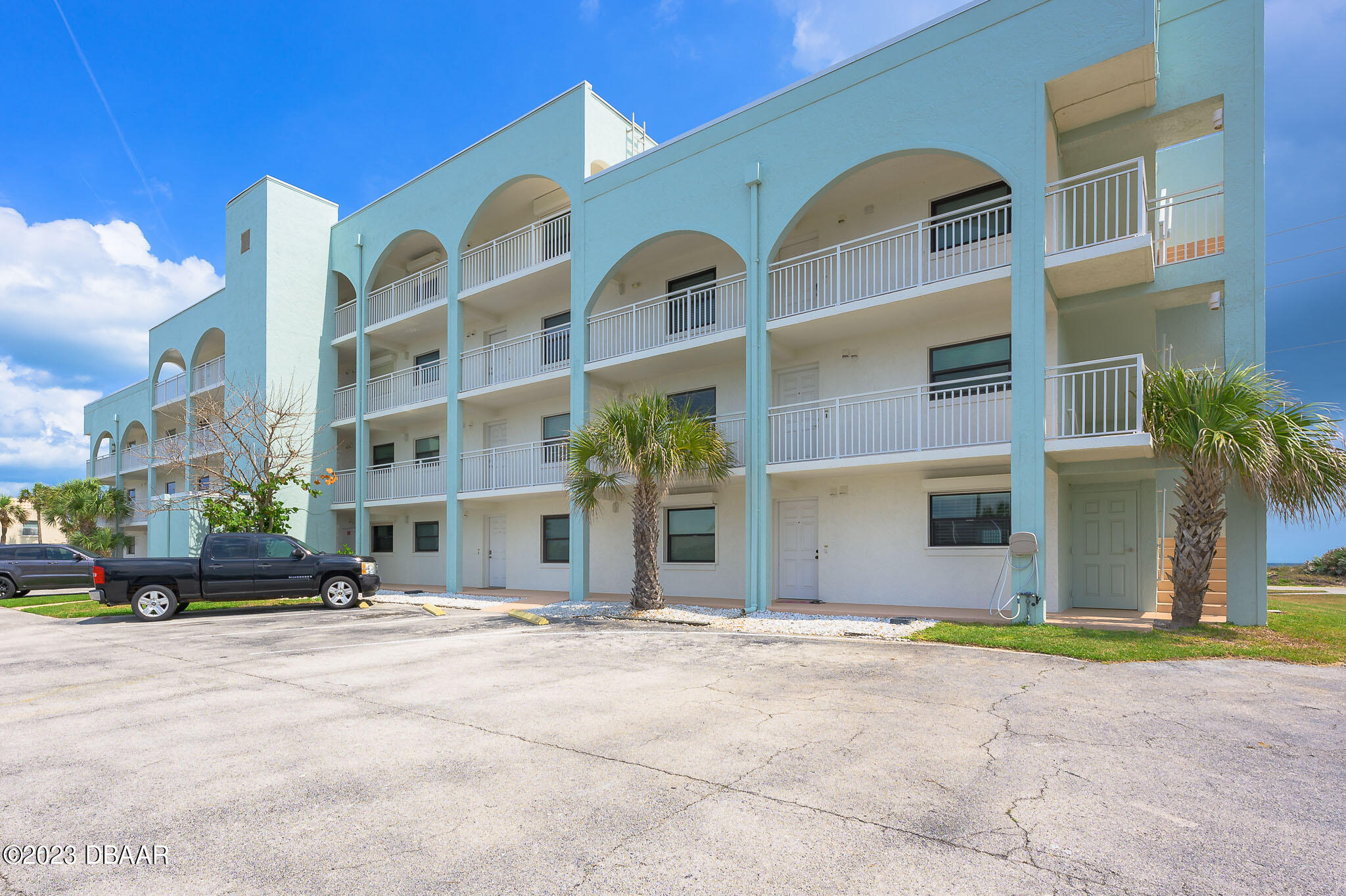 3390 Ocean Shore Boulevard, Unit 202 Ormond Beach, FL 32176 - Photo 8 of 29 a front view of a building with a garden