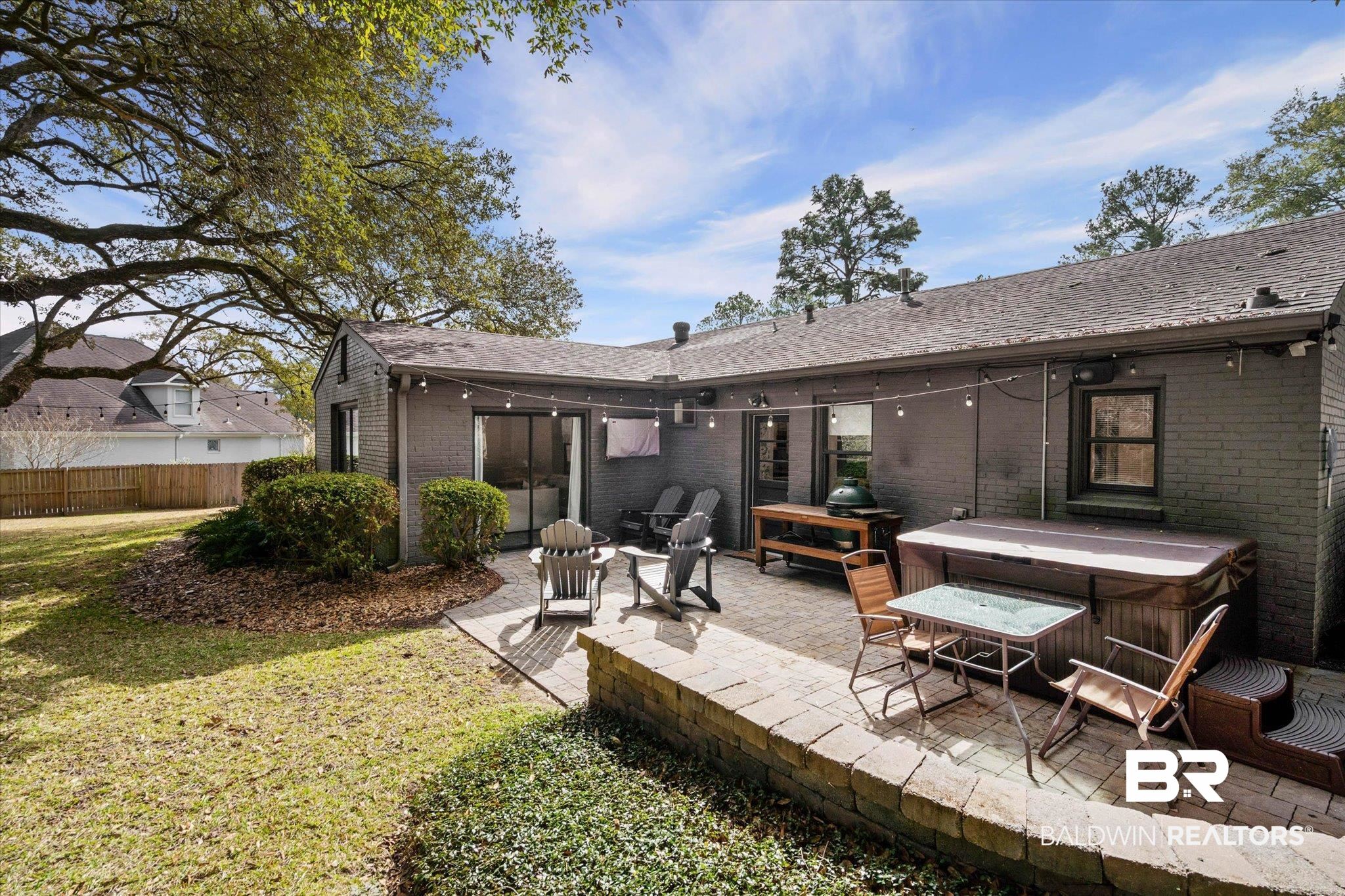 4590 Sunset Drive North Mobile, AL 36608 - Photo 28 of 35 Back of property featuring a hot tub, brick siding, a patio, and a shingled roof