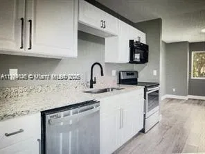 a kitchen with stainless steel appliances granite countertop a sink stove and microwave