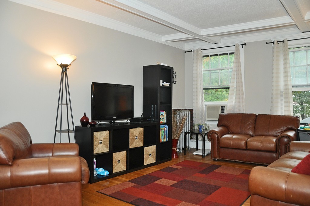 30 Kinross Road, Unit 12 Boston, MA 02135 - Photo 2 of 11 a living room with furniture and a flat screen tv
