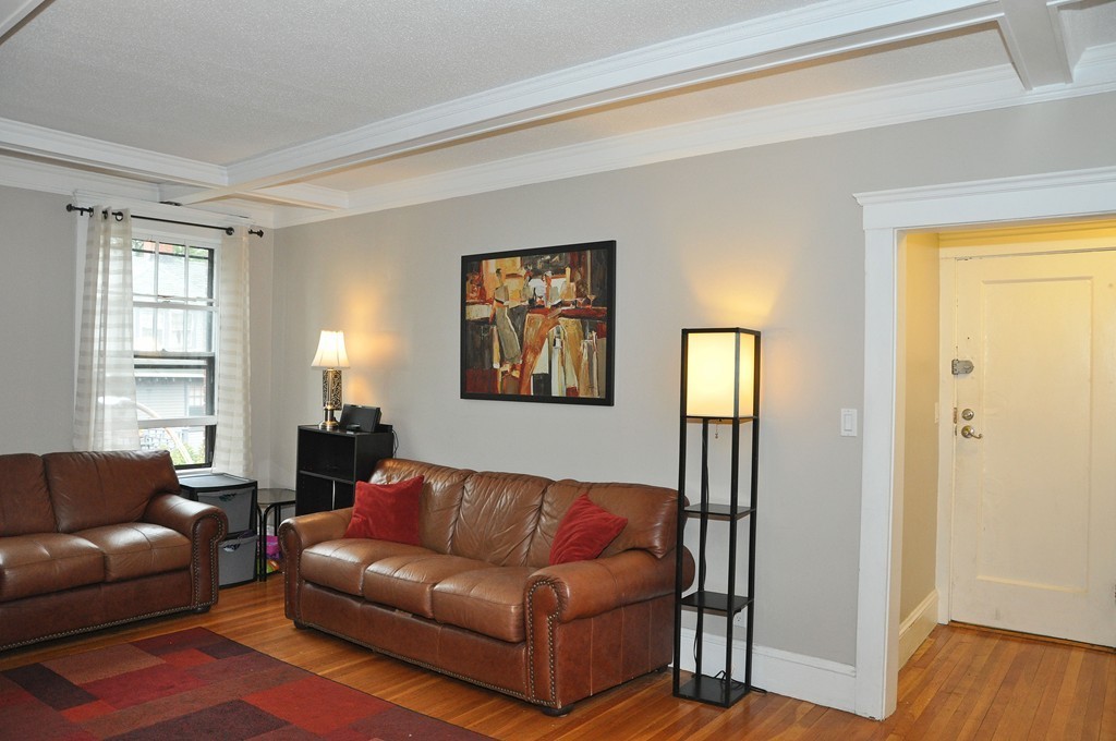 30 Kinross Road, Unit 12 Boston, MA 02135 - Photo 3 of 11 a living room with a couch and a window with wooden floor