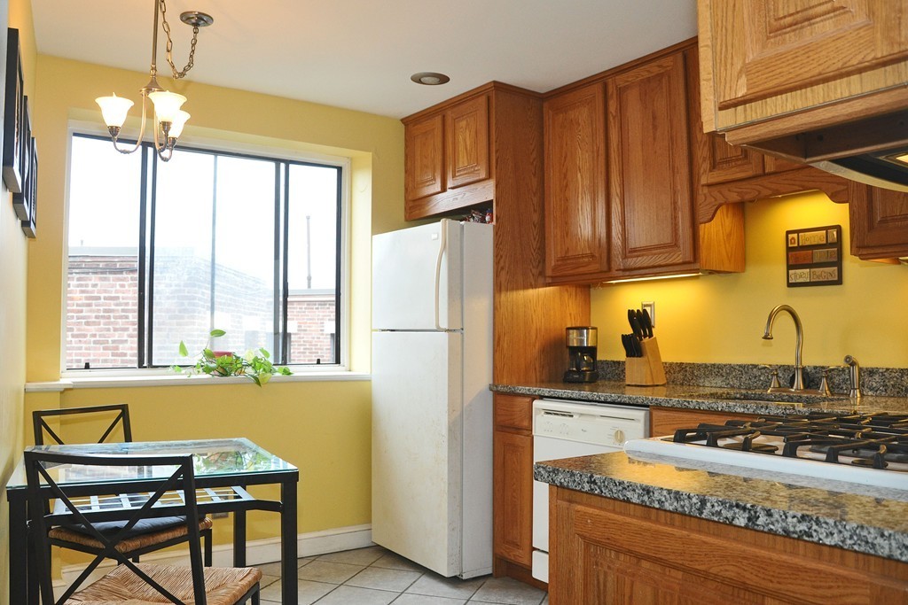 30 Kinross Road, Unit 12 Boston, MA 02135 - Photo 4 of 11 a kitchen with a refrigerator a stove a sink and cabinets