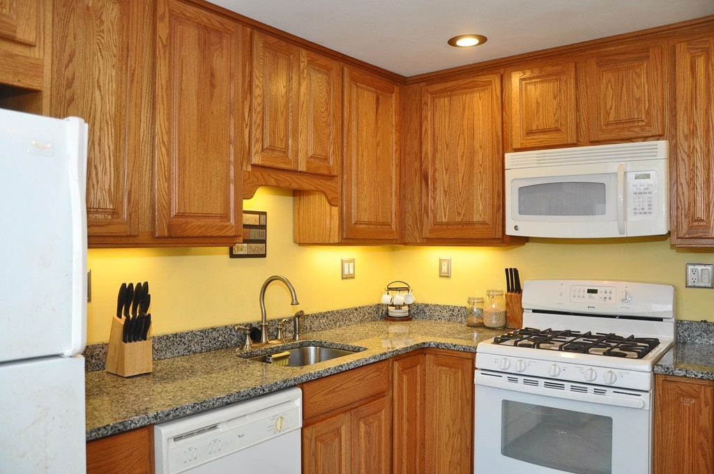 30 Kinross Road, Unit 12 Boston, MA 02135 - Photo 5 of 11 a kitchen with stainless steel appliances granite countertop a sink stove and cabinets
