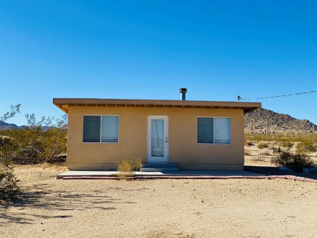 3520 Powell Road Landers, CA 92285 - Photo 1 of 1 a front view of a house with a yard