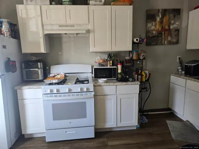 a kitchen with a stove and white cabinets