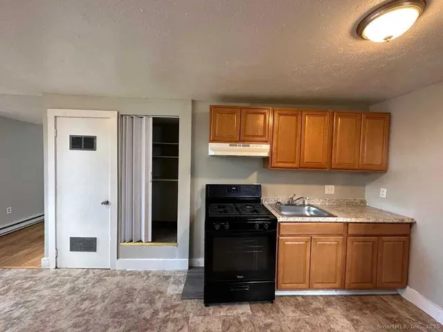 a kitchen with stainless steel appliances granite countertop a stove a refrigerator and a sink