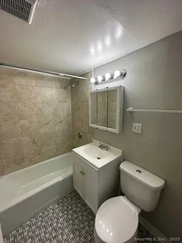a bathroom with a toilet a sink and bathtub