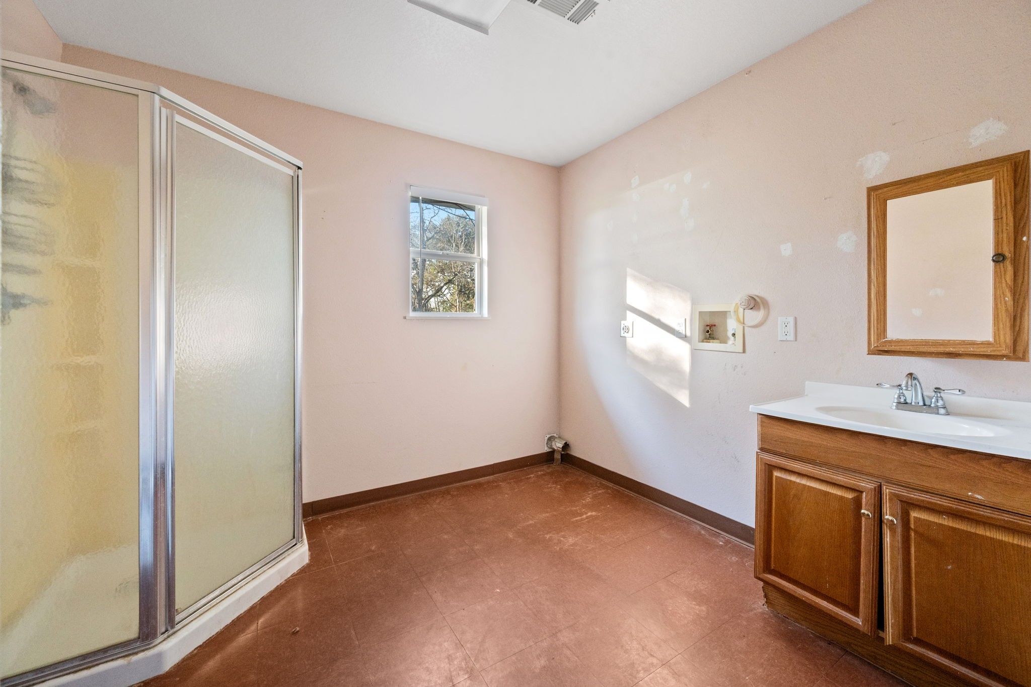 114 Main Street Hull, TX 77564 - Photo 12 of 25 a bathroom with a sink a mirror and a window