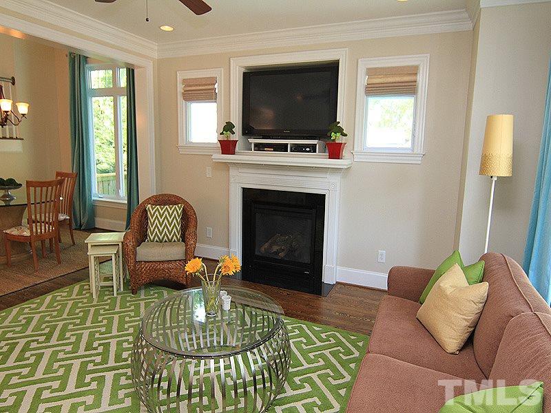 619 Mills Street Raleigh, NC 27608 - Photo 15 of 25 a living room with furniture a flat screen tv and a fireplace