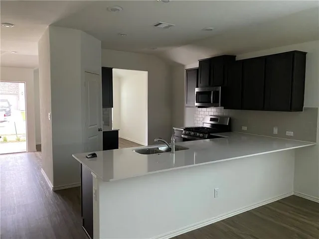 a kitchen with a sink cabinets and wooden floor