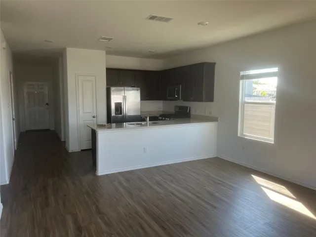 a kitchen with a sink a microwave and cabinets