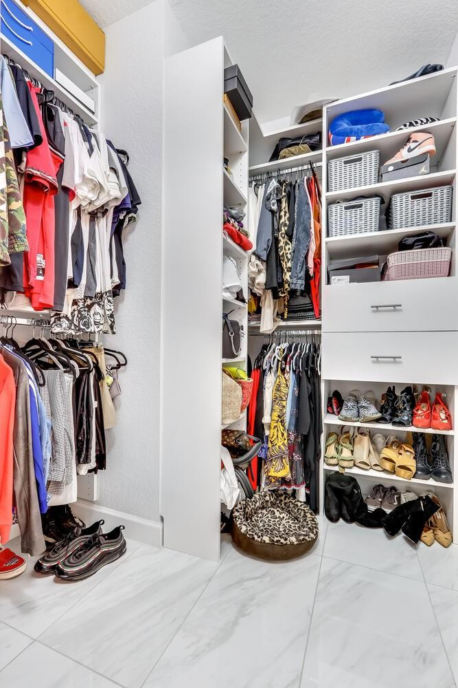 6882 West Sample Road, Unit 6882 Pompano Beach, FL 33063 - Photo 13 of 26 a view of walk in closet with clothes and shoes