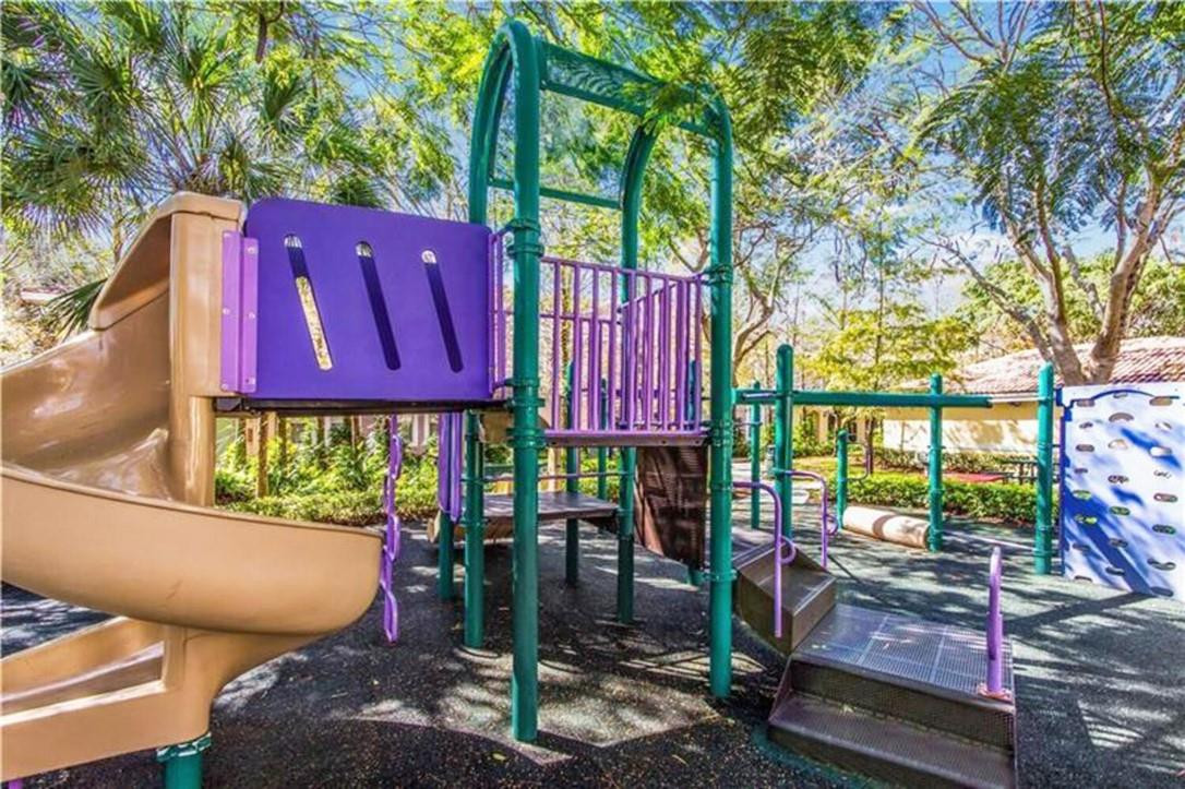 6882 West Sample Road, Unit 6882 Pompano Beach, FL 33063 - Photo 21 of 26 a view of a chairs and table in a backyard