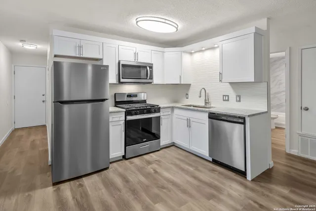 a kitchen with stainless steel appliances a refrigerator stove and microwave