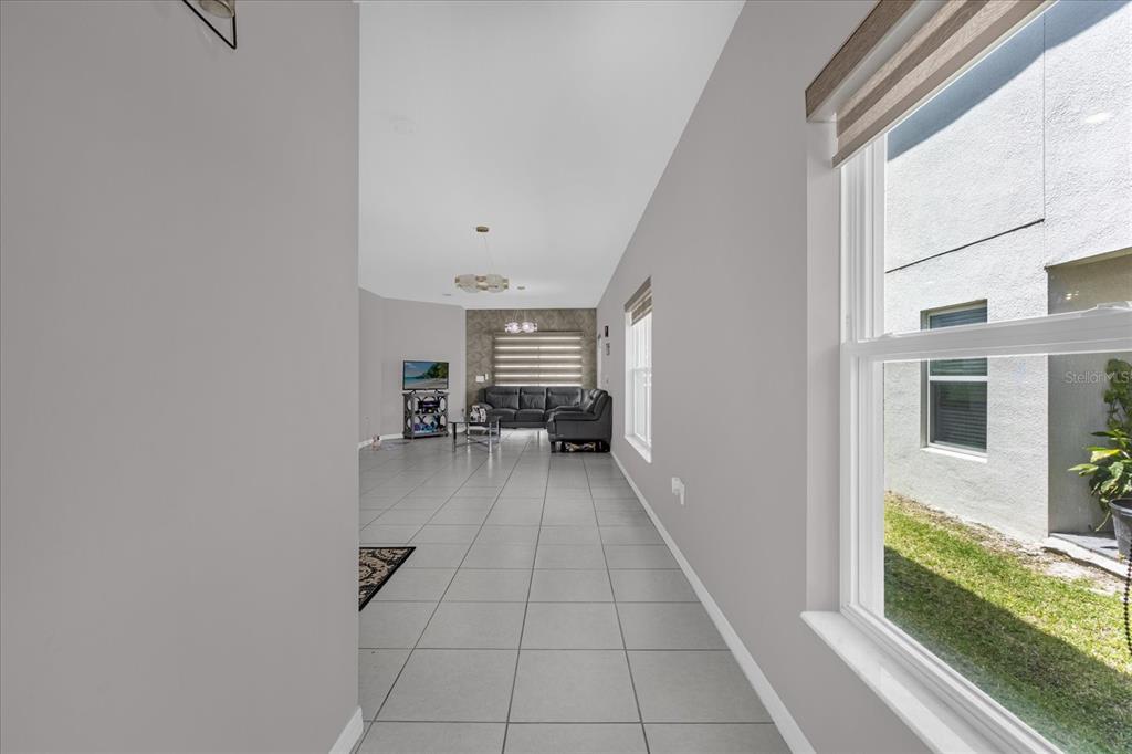 3470 Beau Road Kissimmee, FL 34746 - Photo 6 of 40 a view of a hallway with a livingroom with furniture