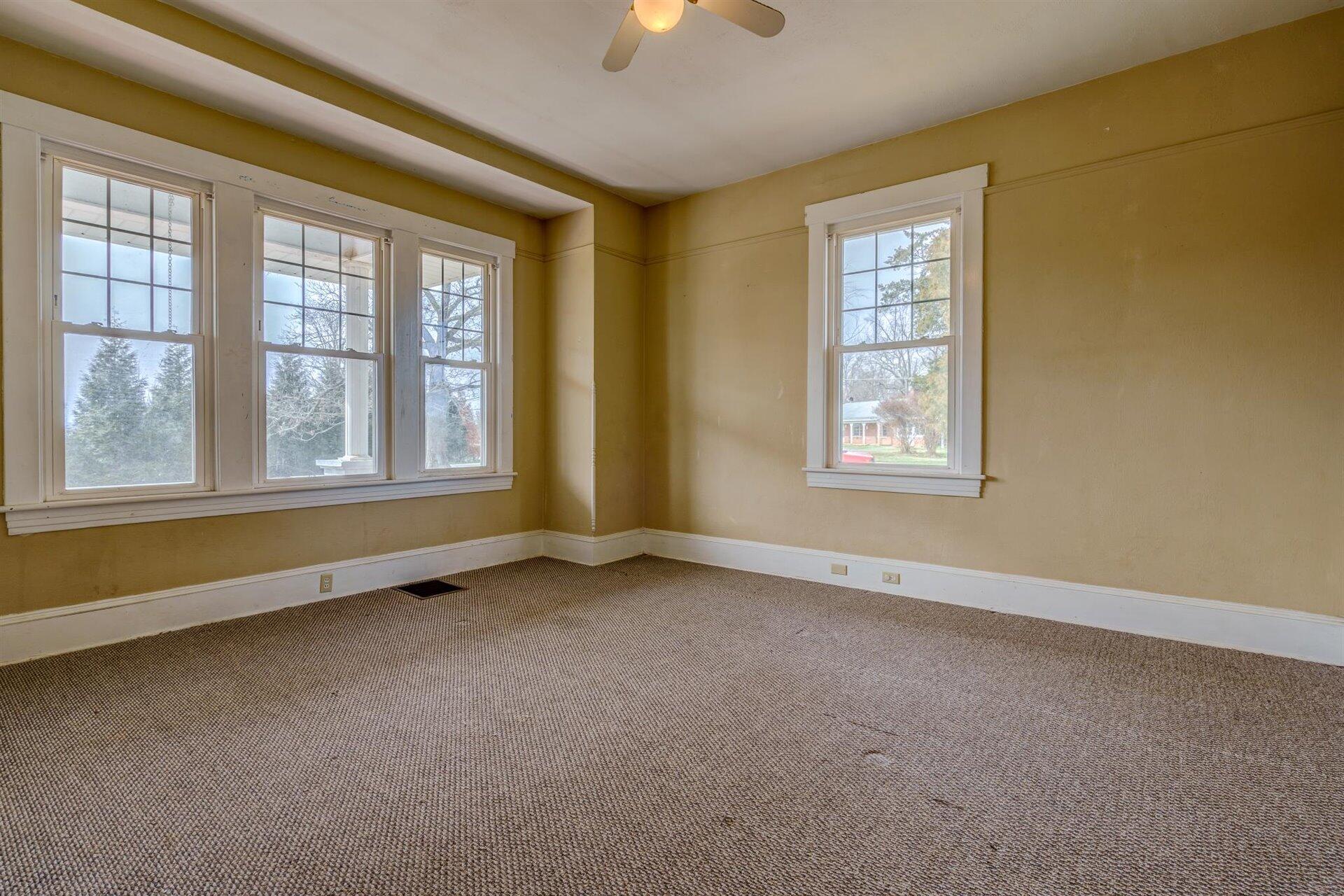 185 Tabernacle Road Penhook, VA 24137 - Photo 17 of 37 an empty room with chandelier fan and windows