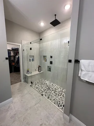 a bathroom with a sink shower and a mirror