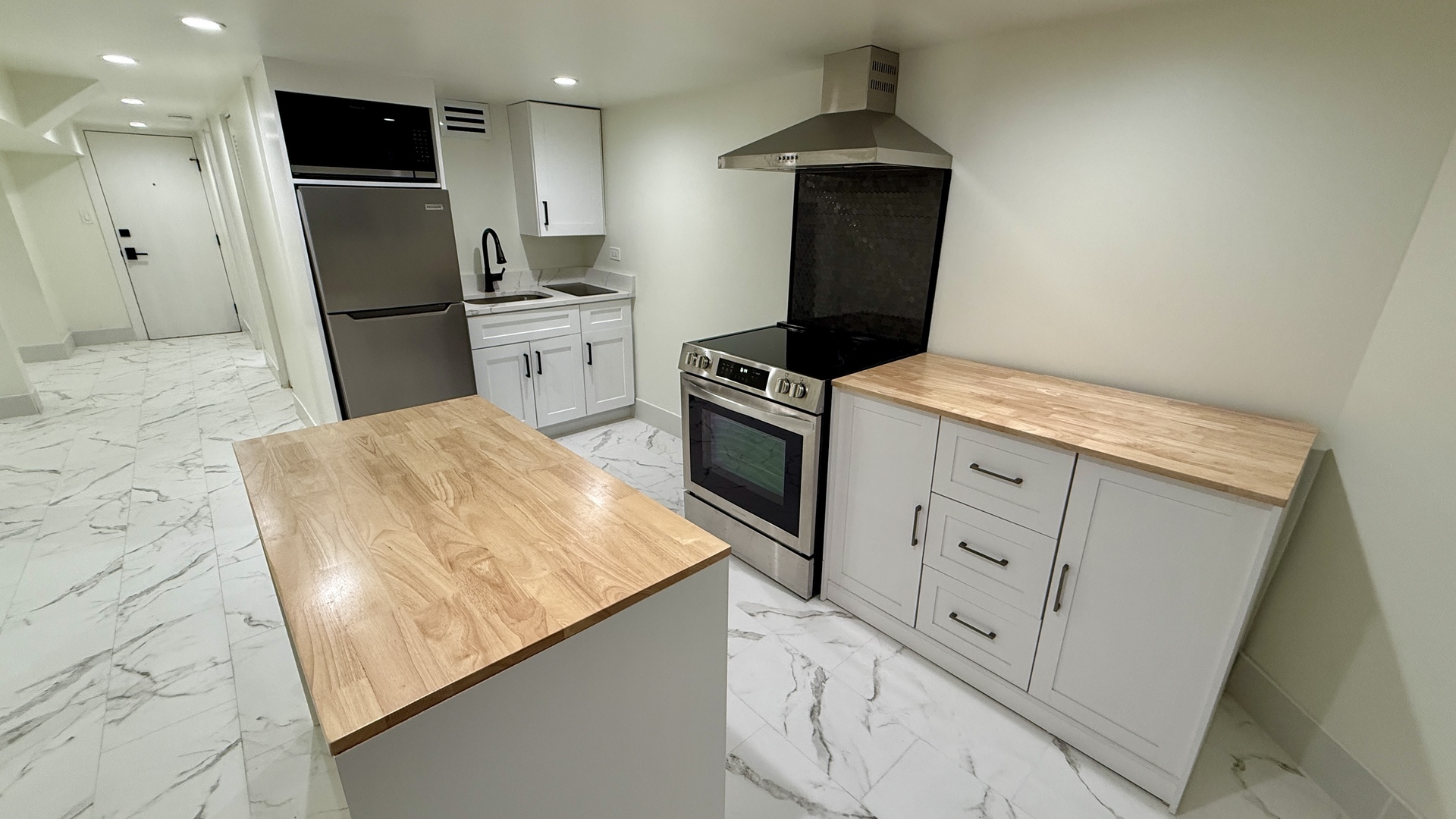 1906 West 34th Place, Unit G Chicago, IL 60608 - Photo 2 of 10 a kitchen with stainless steel appliances granite countertop a refrigerator a stove and a sink