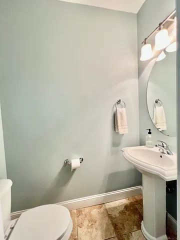 a bathroom with a sink a toilet and mirror