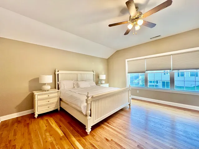 a white bed sitting in a room next to a lamp