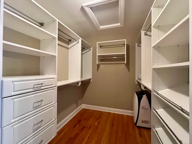 a view of walk in closet with wooden floor