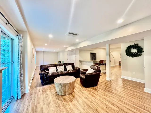 a living room with furniture a flat screen tv and kitchen view