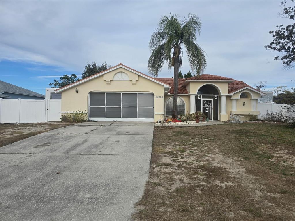 13055 Santee Street Spring Hill, FL 34609 - Photo 1 of 15 a front view of a house with a yard and garage