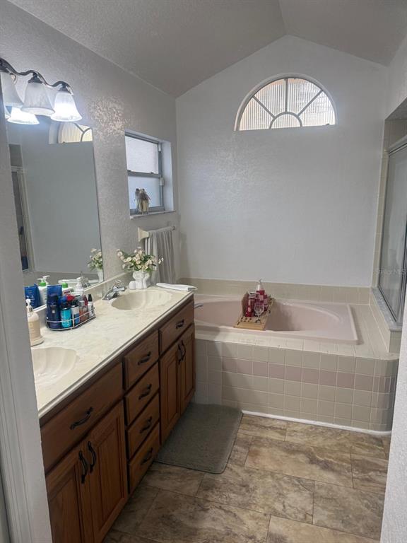 13055 Santee Street Spring Hill, FL 34609 - Photo 13 of 15 a bathroom with a tub sink and mirror