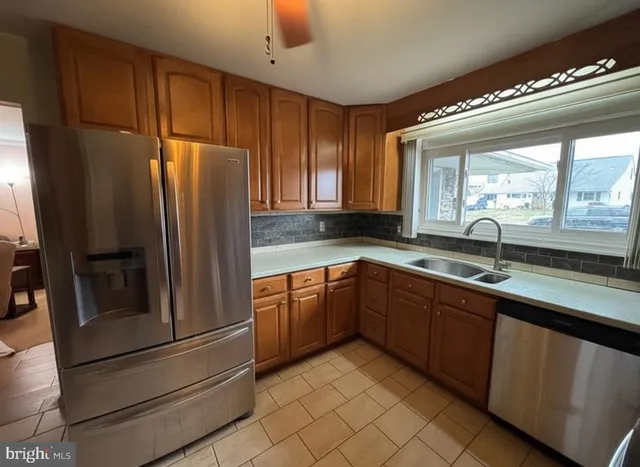 a kitchen with stainless steel appliances granite countertop a refrigerator and a sink