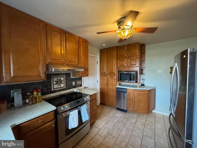 a kitchen with stainless steel appliances granite countertop a stove refrigerator and a sink