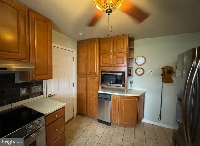 a kitchen with stainless steel appliances granite countertop a refrigerator a stove and a sink