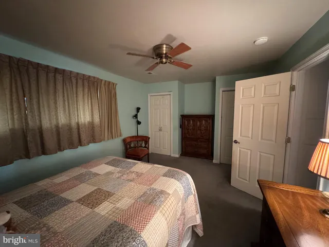 a bedroom with a bed closet and a ceiling fan