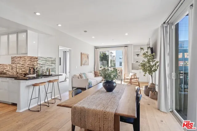 a view of a dining room and livingroom with furniture window and wooden floor