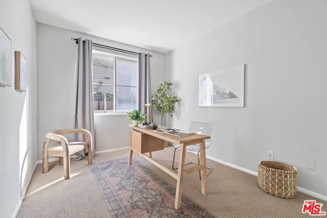 a view of a workspace with furniture and a window