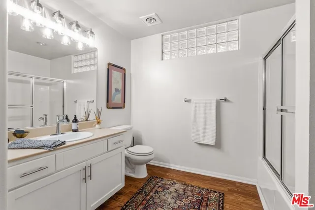 a bathroom with a double vanity sink toilet and mirror