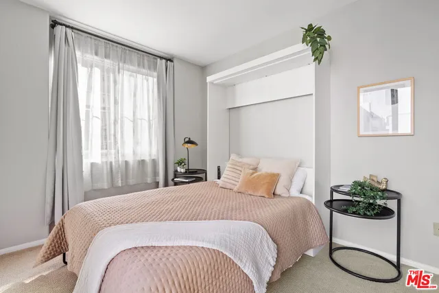 a bedroom with a large bed and a potted plant