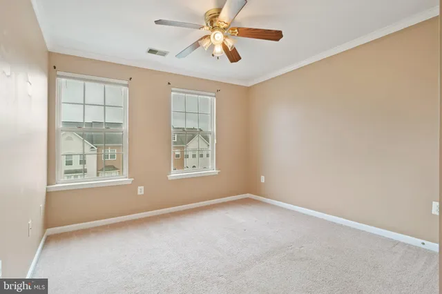 an empty room with windows and fan