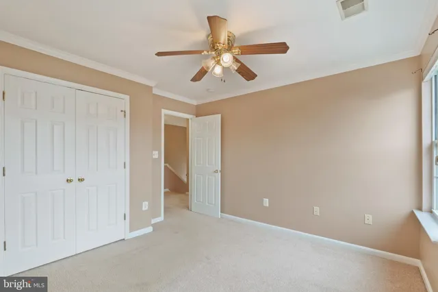 a view of an empty room and chandelier fan