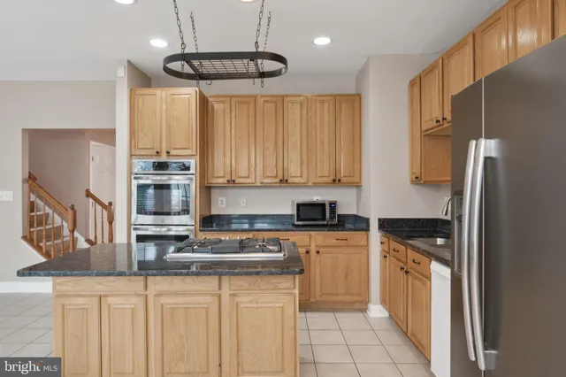 a kitchen with stainless steel appliances a refrigerator sink and microwave