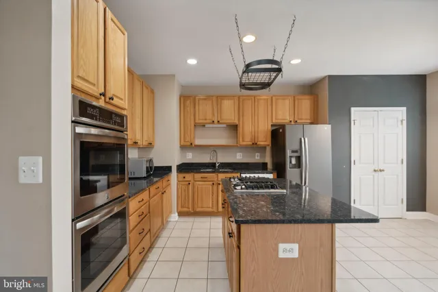 a kitchen with stainless steel appliances granite countertop a stove a sink and a refrigerator