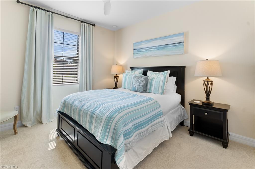 9419 Piacere Way Naples, FL 34113 - Photo 16 of 47 a spacious bedroom with a bed and a lamp