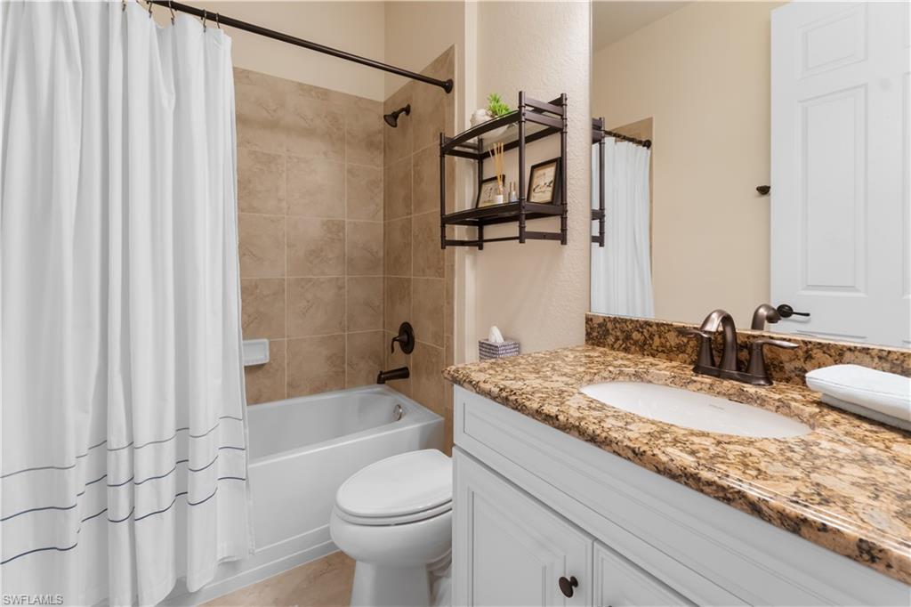 9419 Piacere Way Naples, FL 34113 - Photo 17 of 47 a bathroom with a granite countertop sink and a mirror