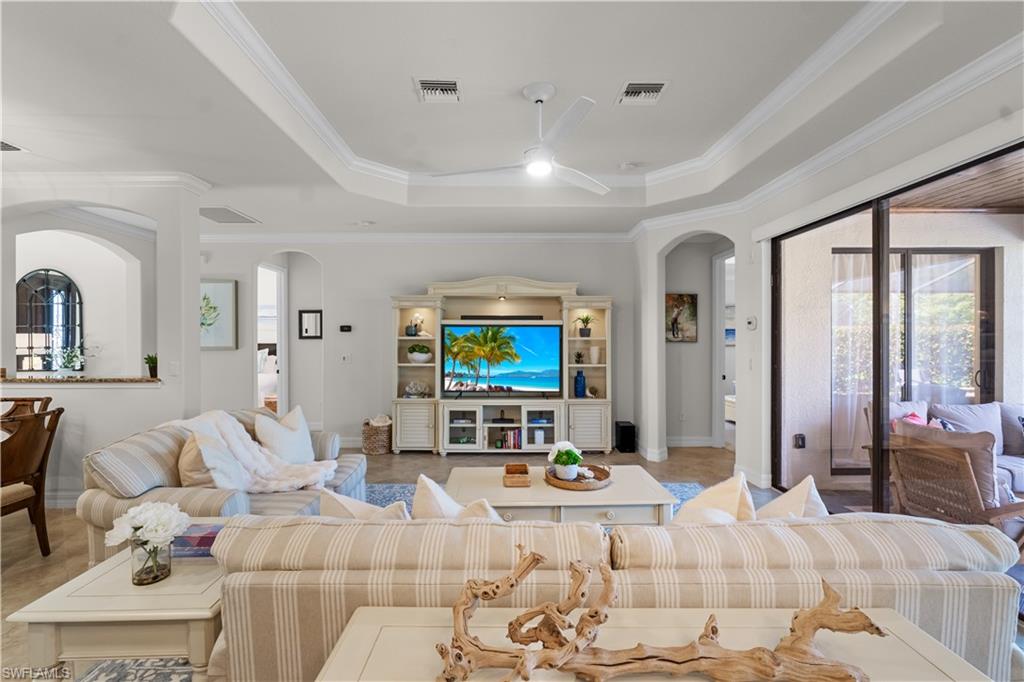 9419 Piacere Way Naples, FL 34113 - Photo 7 of 47 a living room with furniture a flat screen tv and a large window