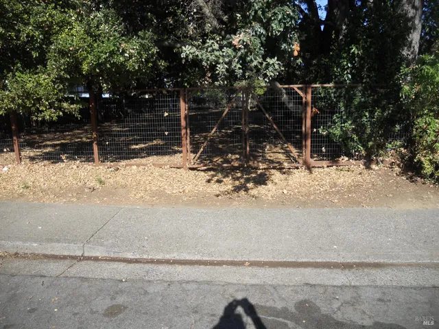 a view of a yard with wooden fence